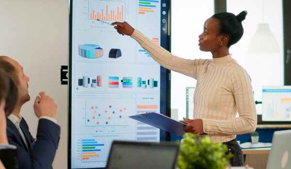 Corporate business people meeting in boardroom, african manager brainstorming with colleagues, discussing strategy, sharing problem, solving ideas collaborating in conference room of company